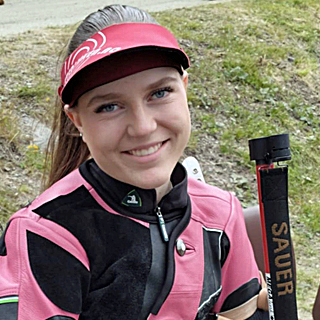 Portrett av Antonie Anna Knutsen sittende på en stol ikledd skytedress.